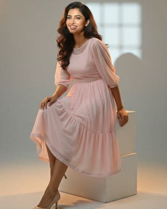 Woman in a pink dress standing on a white platform with a neutral background